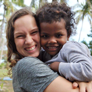 Mackenzie Skiff holding a child in Fiji.