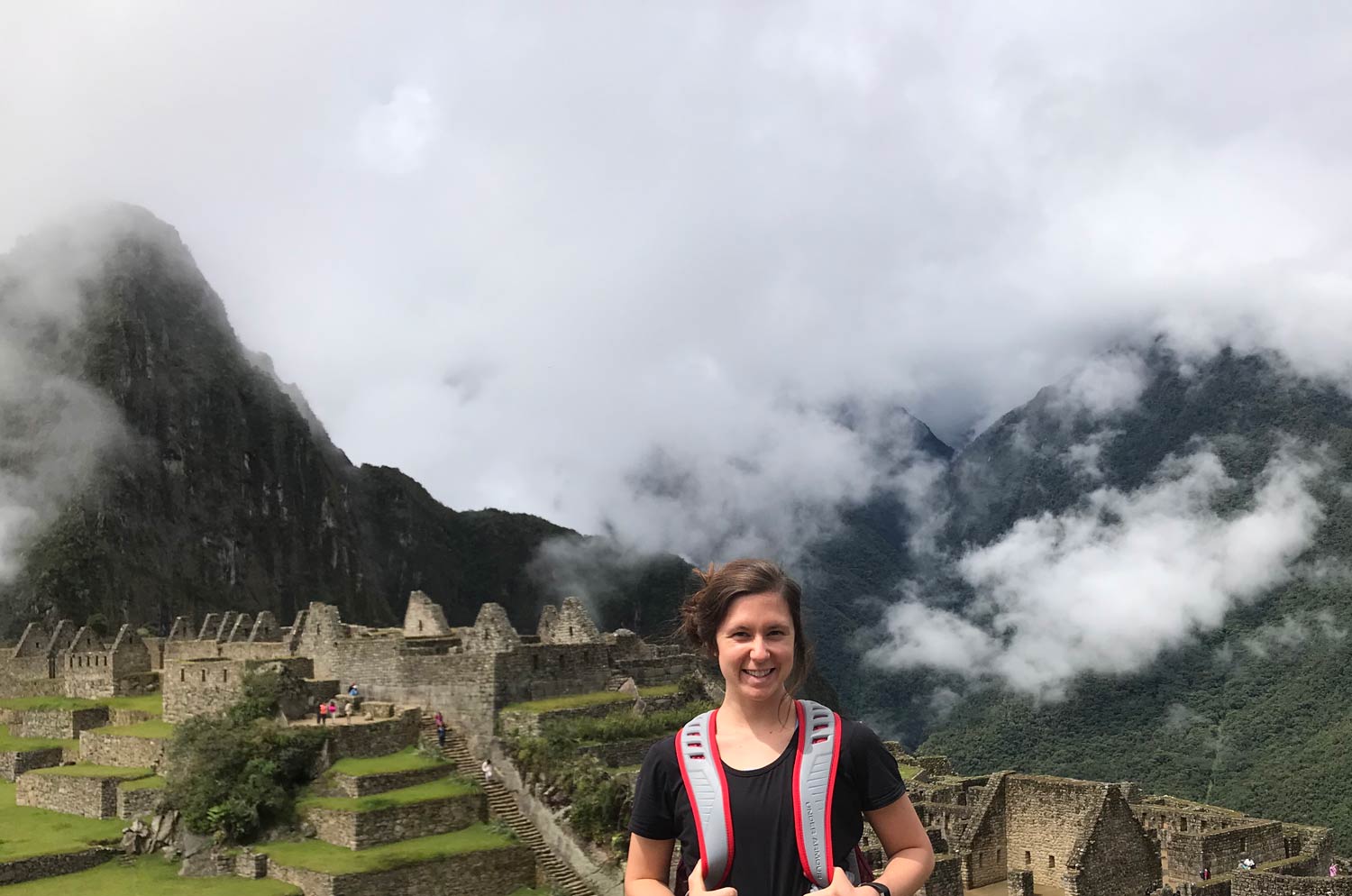 Tori Haynes standing in front of mountain range with fog lifting.