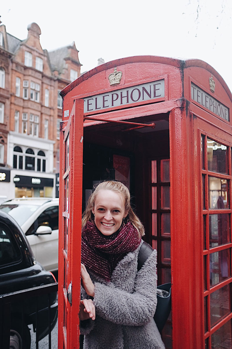 Abbi-Storm McCann standing in a red telephone booth.