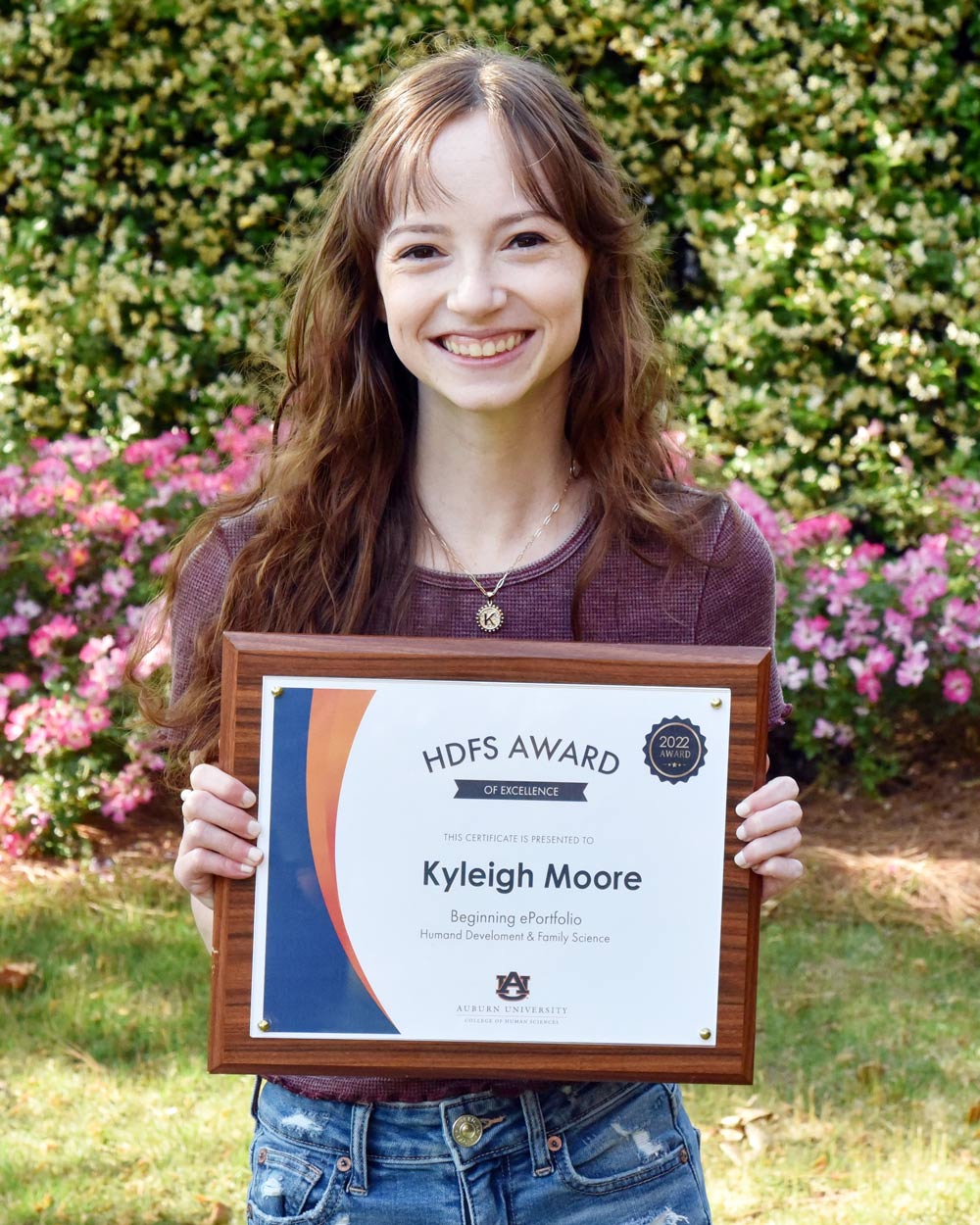 Kyleigh holding a plaque of her Beginning ePortfolio award.