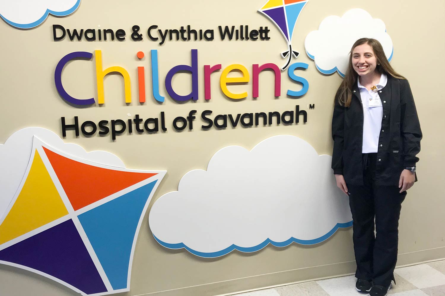 Leigh standing in front of the Children's Hospital of Savannah wall sign.