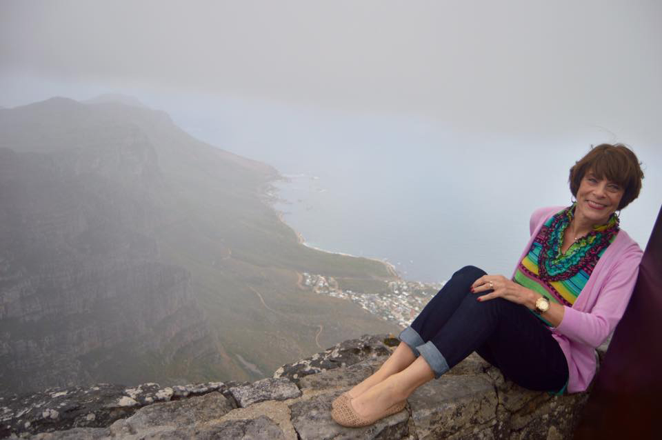 Harriet Giles sitting on a cliff in South Africa.