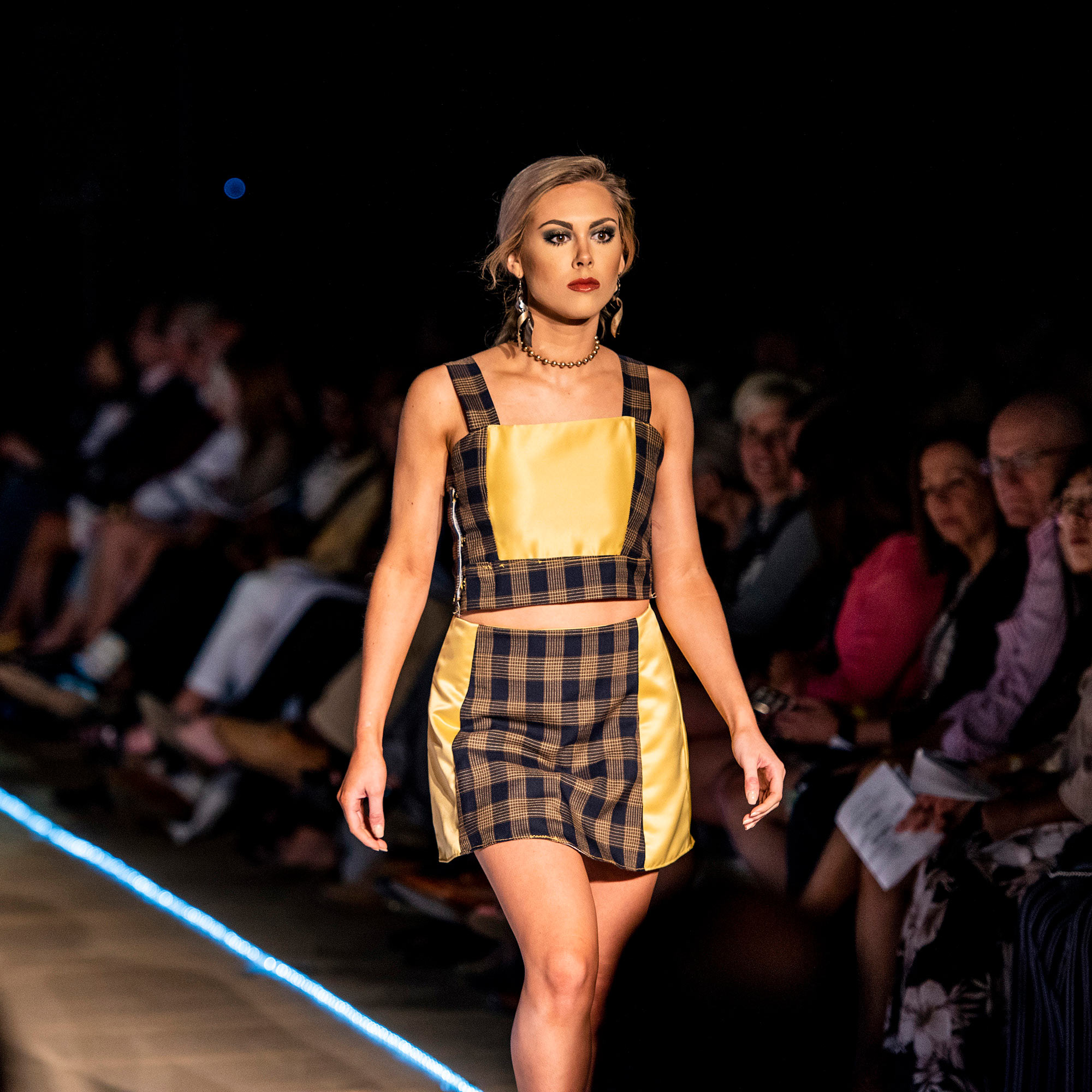 Model walking the runway in a plaid and yellow two piece skirt during The Fashion Event: Mod.