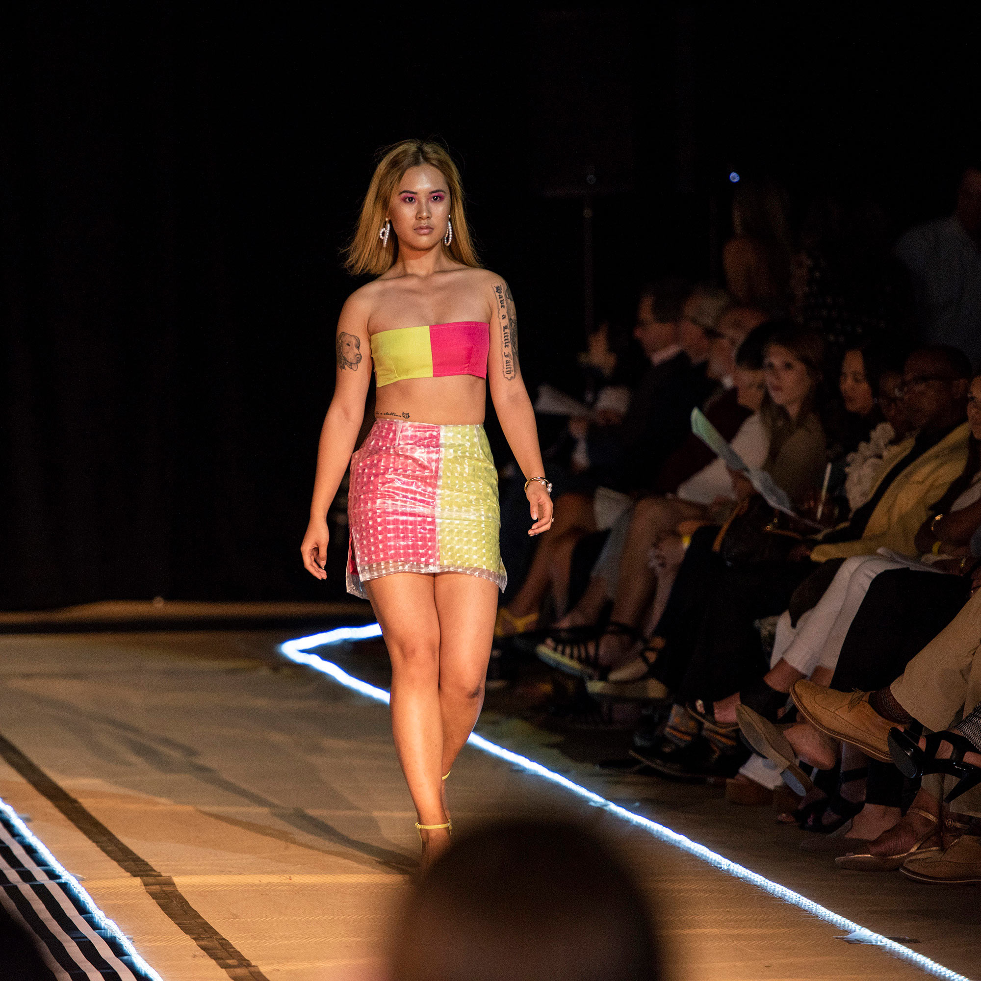 Model walking the runway in a brigth yellow and fushcia halter top and skirt during The Fashion Event: Mod.