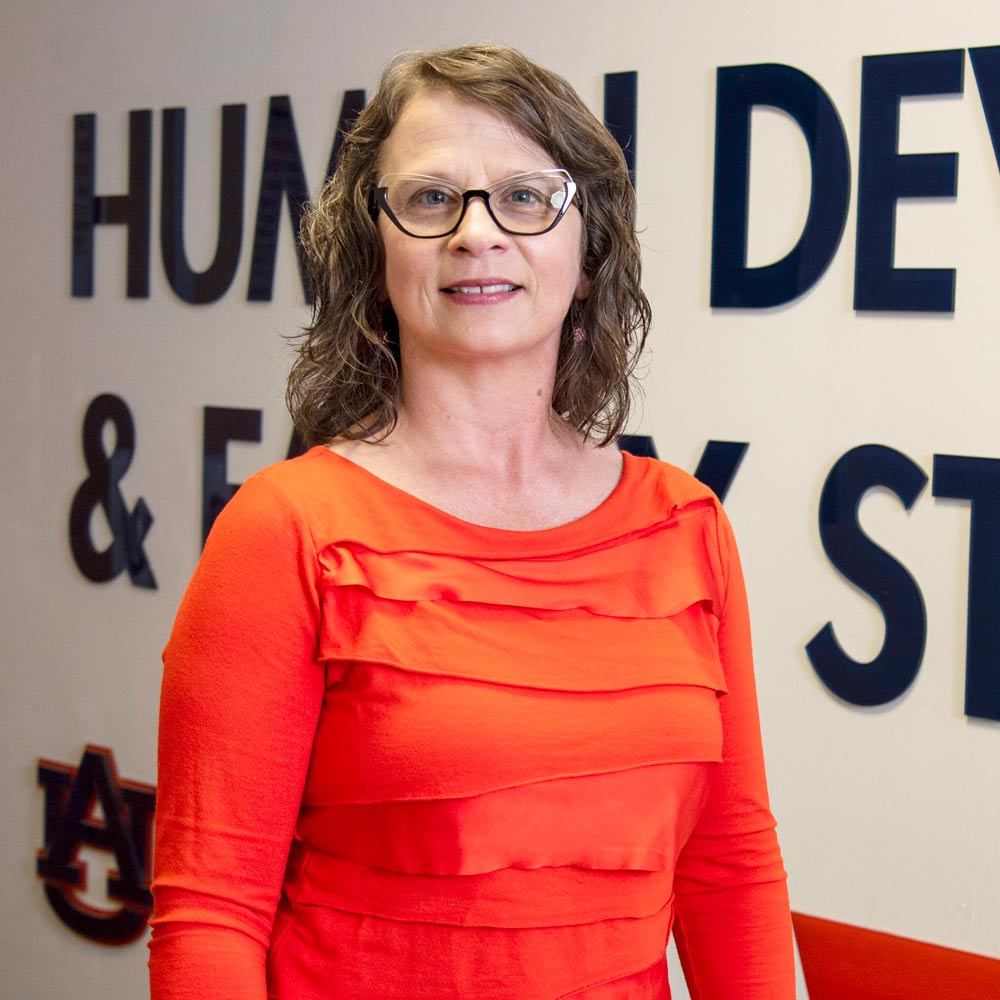 Angela Wiley standing in front of the HDFS wall sign.
