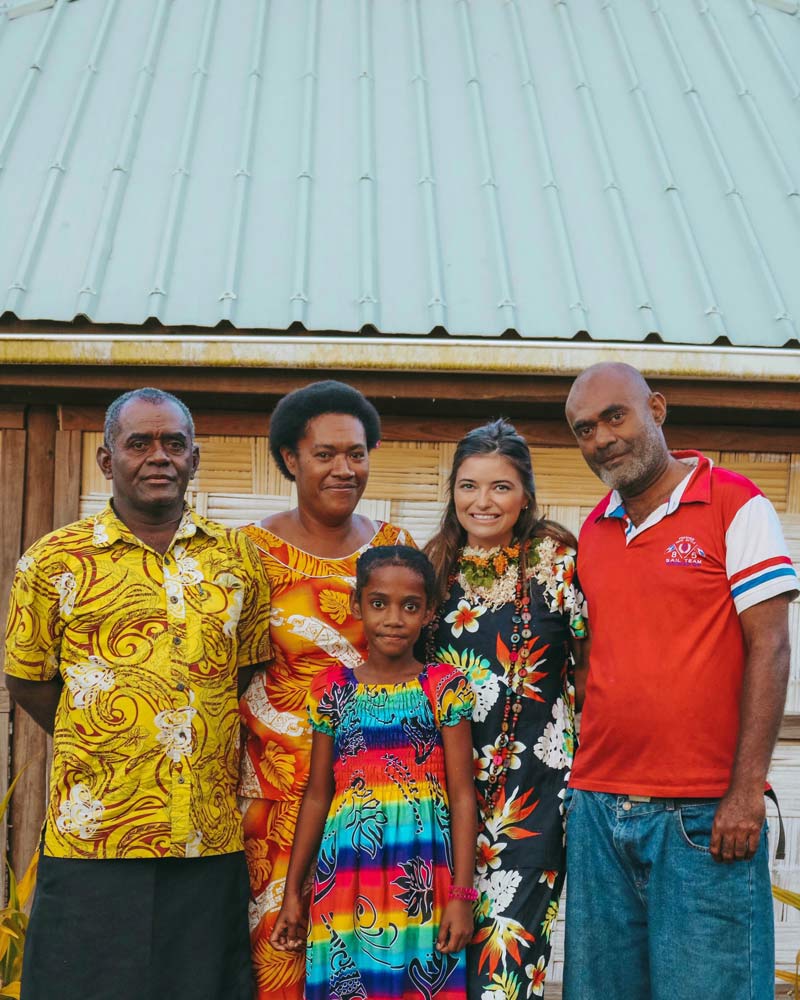Shelby Sires posing with a family in Fiji.