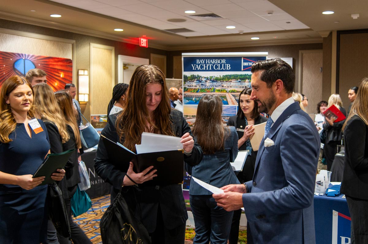 Two female students speaking with a couple of vendor reps.