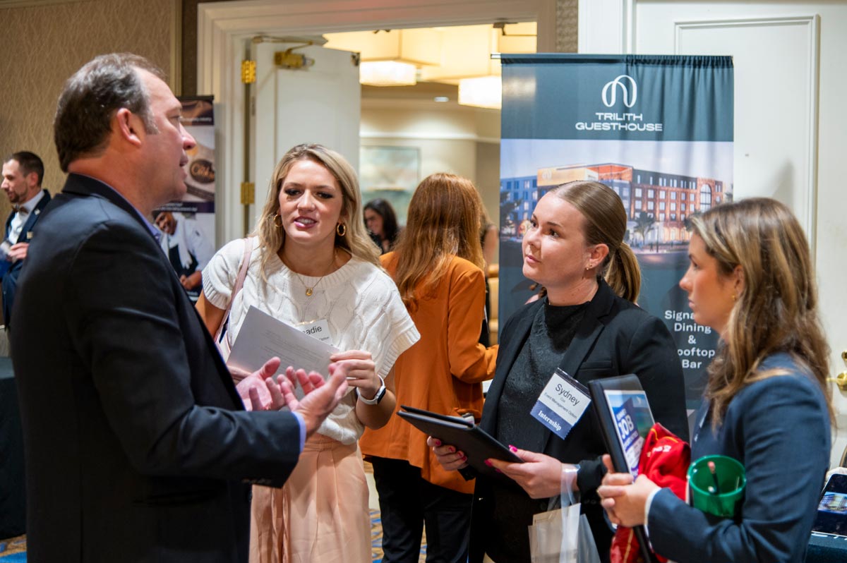 Female student with a big smile while speaking with one of the companies represented career fair.