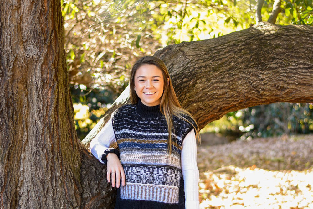 Taylor Blain standing in front of an Oak tree.